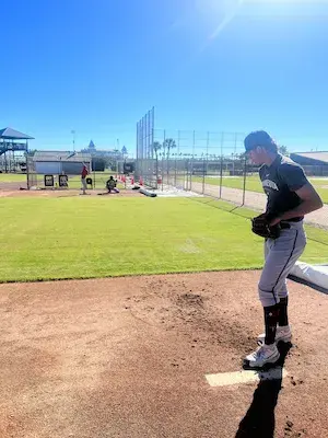 Competitive pro baseball pitcher practicing proper throwing mechanics to avoid UCL debt.